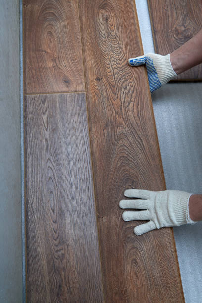 istock Skills in action as hands lay new wooden flooring in a modern interior setting 2194237488