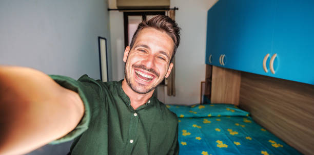 istock Handsome young man taking selfie pic with smart mobile phone indoor - Smiling guy looking at camera at home - People and technology concept 2194237493