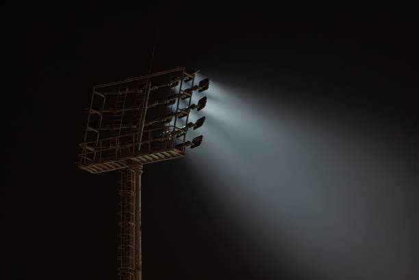 istock Stadium lights illuminating night sky with beams of light 2194240585