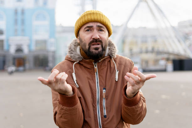 istock Confused man gesturing with hands in urban setting 2194242866