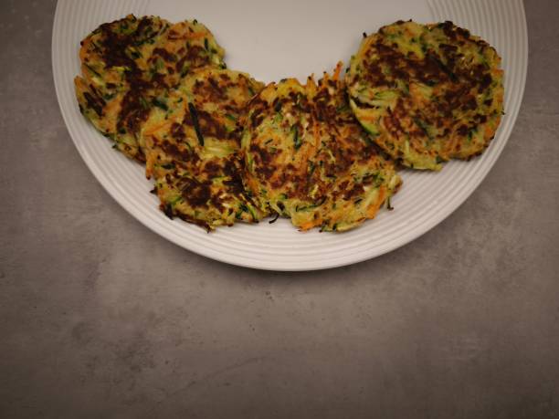 istock Delicious zucchini and carrot pancakes resting on a white plate 2194243208