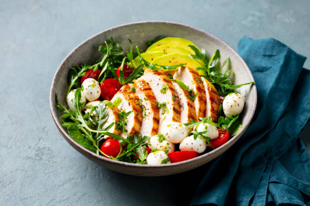 istock Warm grilled chicken salad with avocado and mozzarella cheese. Close up. 2194243283