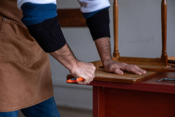 istock Carpenter restoring old furniture with chisel and hammer 2194243303