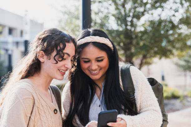 istock Two smiling young women looking at a smart phone together 2194243746