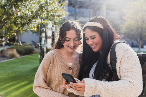 istock Two Smiling Young Women Using Smart Phone Outdoors 2194243752