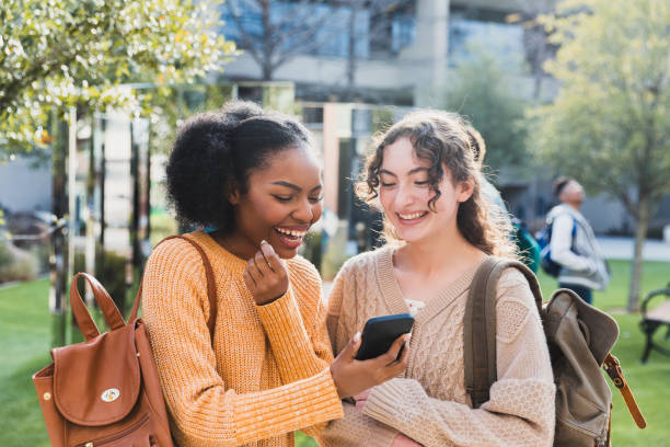 istock Two Teenagers Smiling While Looking at a Smartphone Outdoors 2194243756