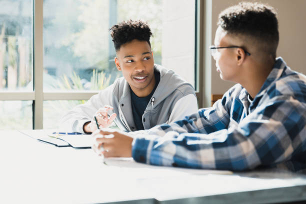 istock Two Black Male Students Discussing Homework in Classroom 2194243761
