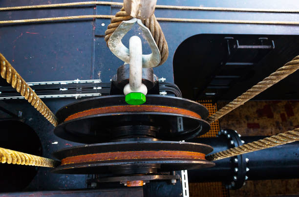 Stretched steel cable, on the roller of a cargo crane, close-up.