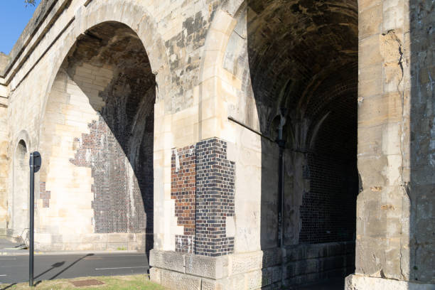 istock Historic Railway Viaduct with road leading through and showing original brick through plastered coating. 2194244257