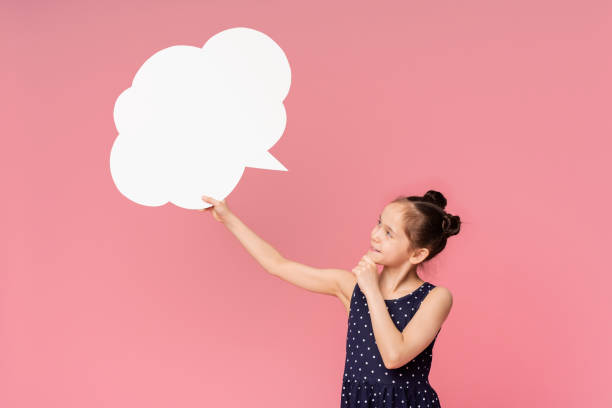 istock Young Girl Holding Speech Bubble in Front of Pink Background While Thinking 2194244468