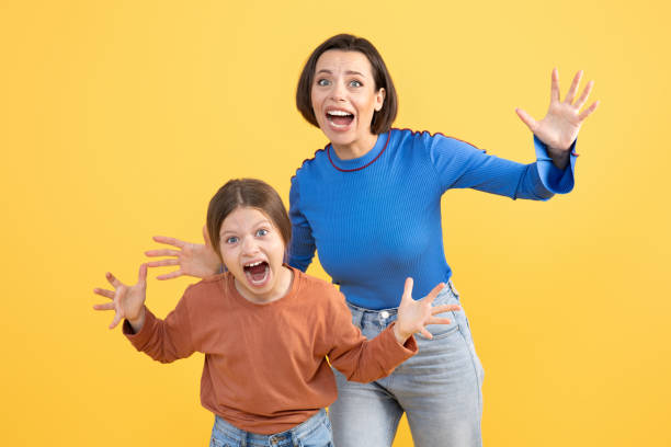istock Mother and daughter express joy together in a vibrant yellow setting 2194244616