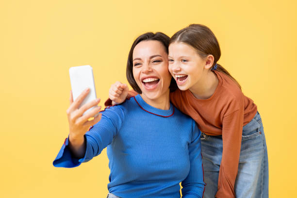 istock Mother and daughter sharing joyful moments while taking selfies together 2194244661