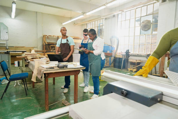 istock Group of craftsmen talking in woodshop 2194245721