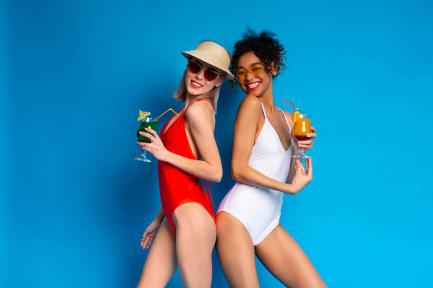 istock Friends Enjoying Colorful Drinks While Posing in Swimwear Against a Bright Backdrop 2194246319