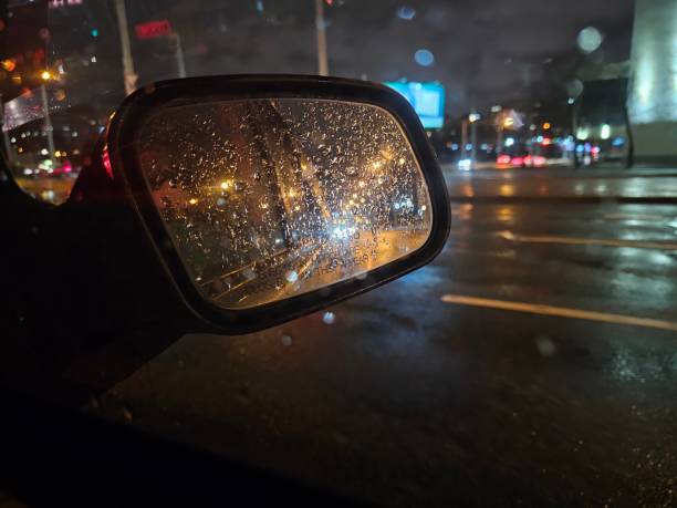 istock Rainy night view from a car side mirror reflecting city lights and traffic on a wet road concept 2194247113