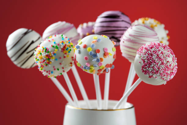 Various cake pops decorated with white and dark chocolate, sprinkled with sugar confetti