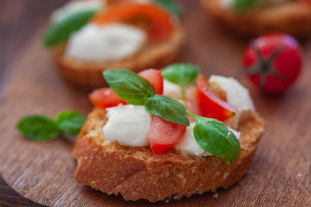 Homemade Caprese toasts with mini mozzarella cheese, cherry tomato and basil