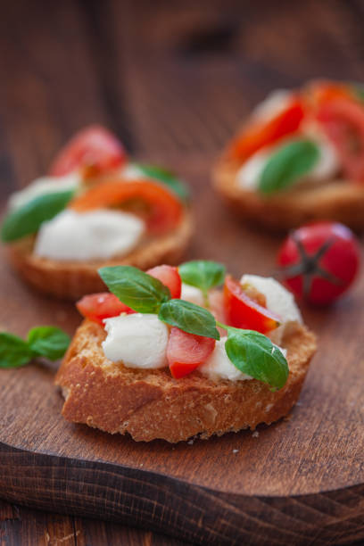 Homemade Caprese toasts with mini mozzarella cheese, cherry tomato and basil