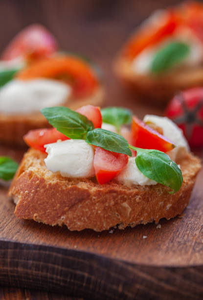 Homemade Caprese toasts with mini mozzarella cheese, cherry tomato and basil