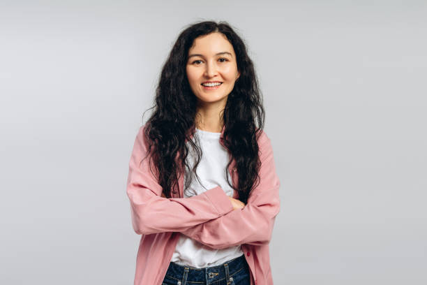 istock Confident young woman smiling with folded arms on white background 2194252916