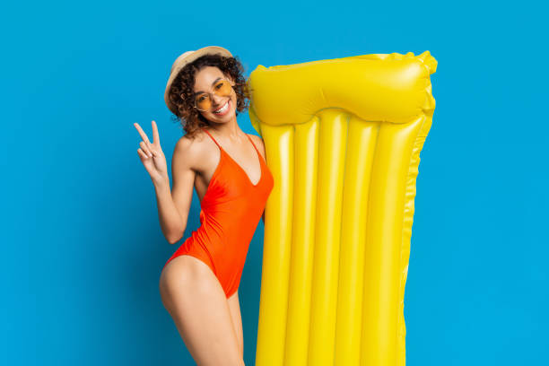 istock Young Woman Enjoys Summer Fun With Floating Mat Against Bright Blue Backdrop 2194253100