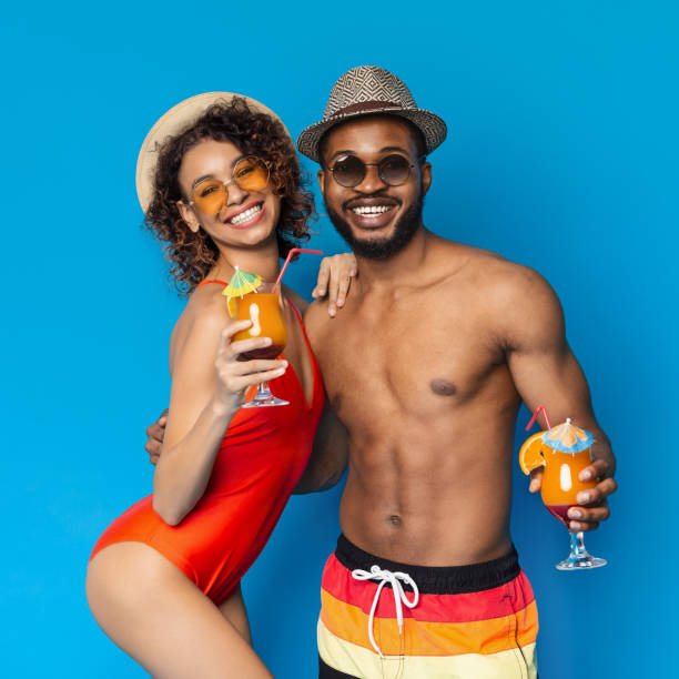 istock Joyful Couple Enjoys Refreshing Drinks on a Bright Blue Background During Summer Vacation 2194253130