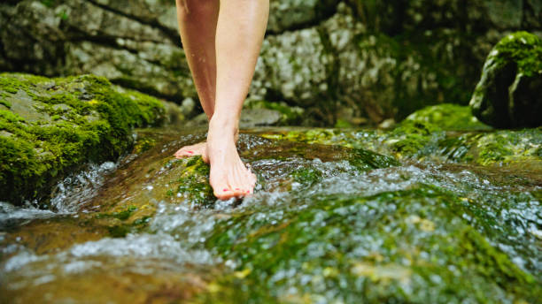 istock Caucasian Female Feet Playing in Clear Spring Water 2194253197