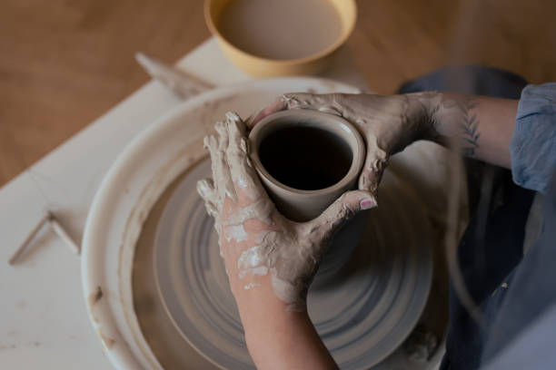 istock Hands of woman working on pottery wheel in studio 2194253784