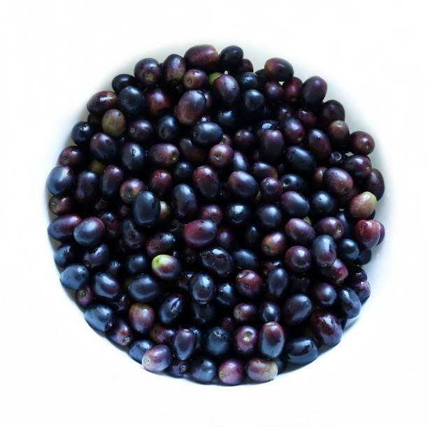 black olives in a spoon on wooden table