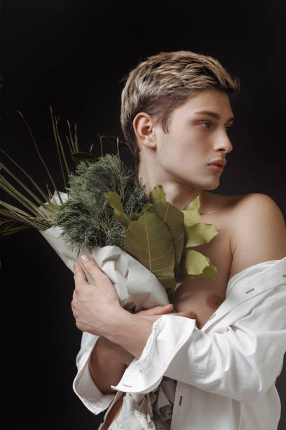 istock Stylized Portrait Of Young Man Holding Green Bouquet With Dramatic Lighting 2194258154