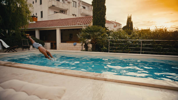 istock Joyful Mid Adult Black Man Diving into Pool at Sunset 2194261565