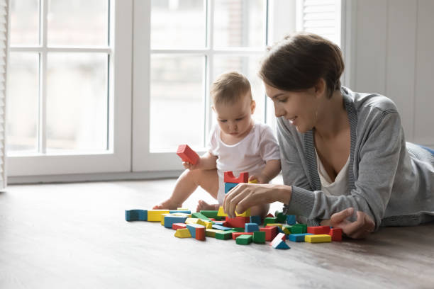 istock Mother and baby play on floor with blocks 2194264150
