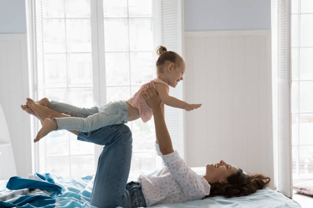 istock Mother holding, lifting daughter, spend morning, exercising, having fun 2194264287