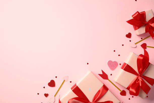 istock Happy Valentine's Day concept. Flat lay composition with pink gift boxes with red ribbon bows, arrows with hearts on pink background 2194264354