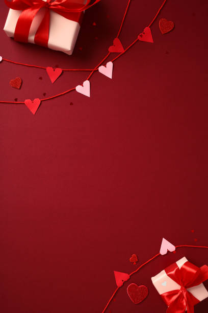 istock Valentine's Day concept with red and pink heart decorations, gift boxes wrapped with red ribbons on deep red background 2194264538