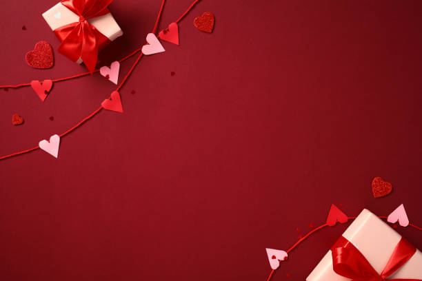 istock Happy Valentine's Day concept. Flat lay composition with red and pink heart decorations on strings, gift boxes wrapped with red ribbons on red background 2194264720