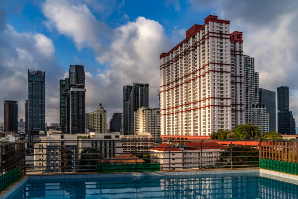 Bangkok, Thailand - February 21, 2024: Nice clear and colorful view over Bangkok skyscrapers and a small swimming pool at a sunny morning with some clouds at the blue sky.