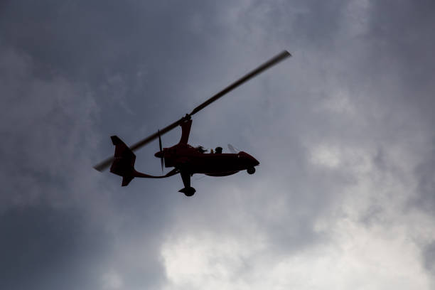 A modern, closed-cabin, pusher-propeller autogyro in flight