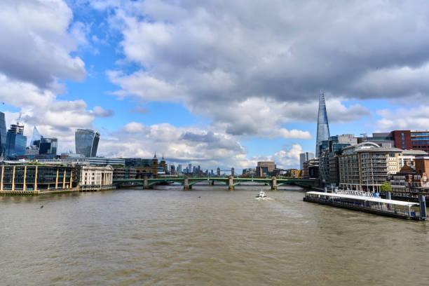 Scenic view of River Thames with London buildings and bridges under a cloudy sky