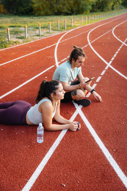 istock Young couple resting after running on a track 2194274343