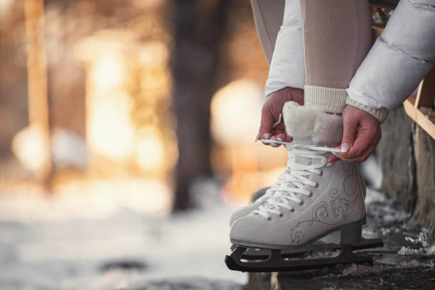 Unrecognizable person tying up the laces on ice skates.