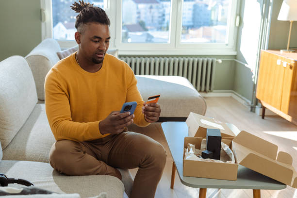 istock Man shopping online at home using mobile phone and credit card 2194279794