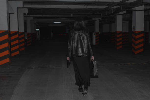 Woman walking into a corridor tunnel towards darkness. Concept about unknown and mystery.