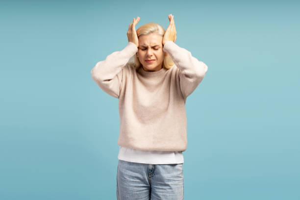 istock Stressed young woman suffering from headache touching temples on blue background 2194288204