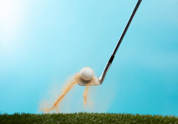 Golf ball explode from Tee off. Golfer hit ball with metal iron club to sand explosion on green. Golf club hit ball on green tee off with sand flying scatter. Blue Sky background isolated