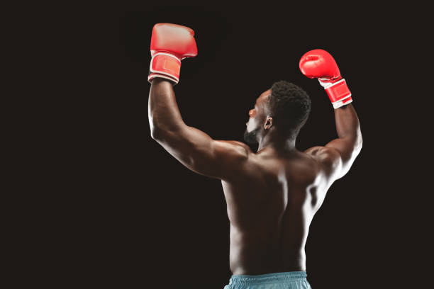 istock African boxer enjoying win, raising hands in boxing gloves 2194292762