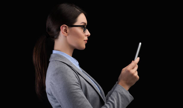 istock Businesswoman Using Smartphone Face Recognition System On Black Background 2194294431
