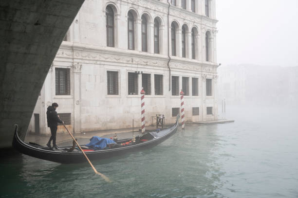 Venice,Italy_Nov 17, 2024Heavy fog on a November morning in Venice. Gondolier owner  heads off for a day’s work.
