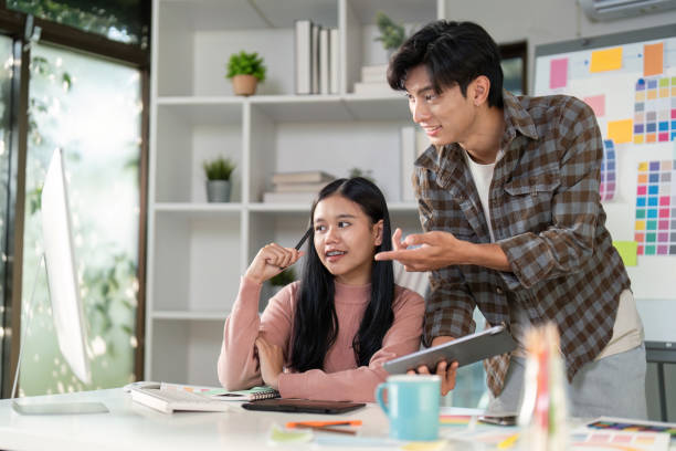 istock Design professionals engaging in a collaborative brainstorming session at a modern workspace, exploring graphics on a tablet 2194297506