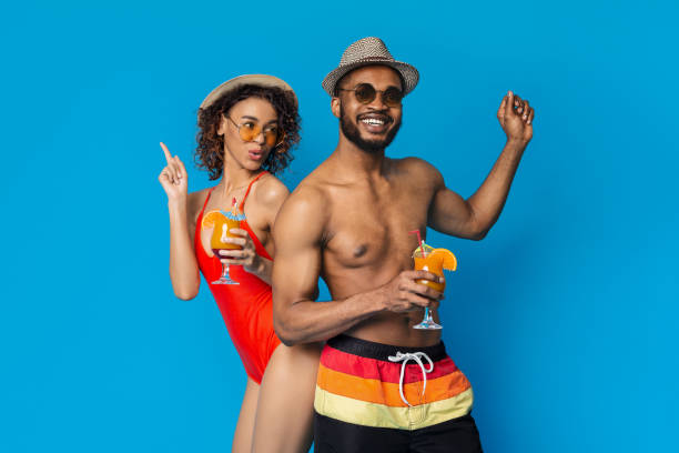istock Couple Enjoying Tropical Drinks While Posing Against a Bright Blue Background at a Summer Party 2194298995